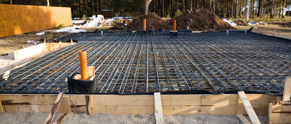 Iron fittings and pipes laid into wooden formwork before concrete
